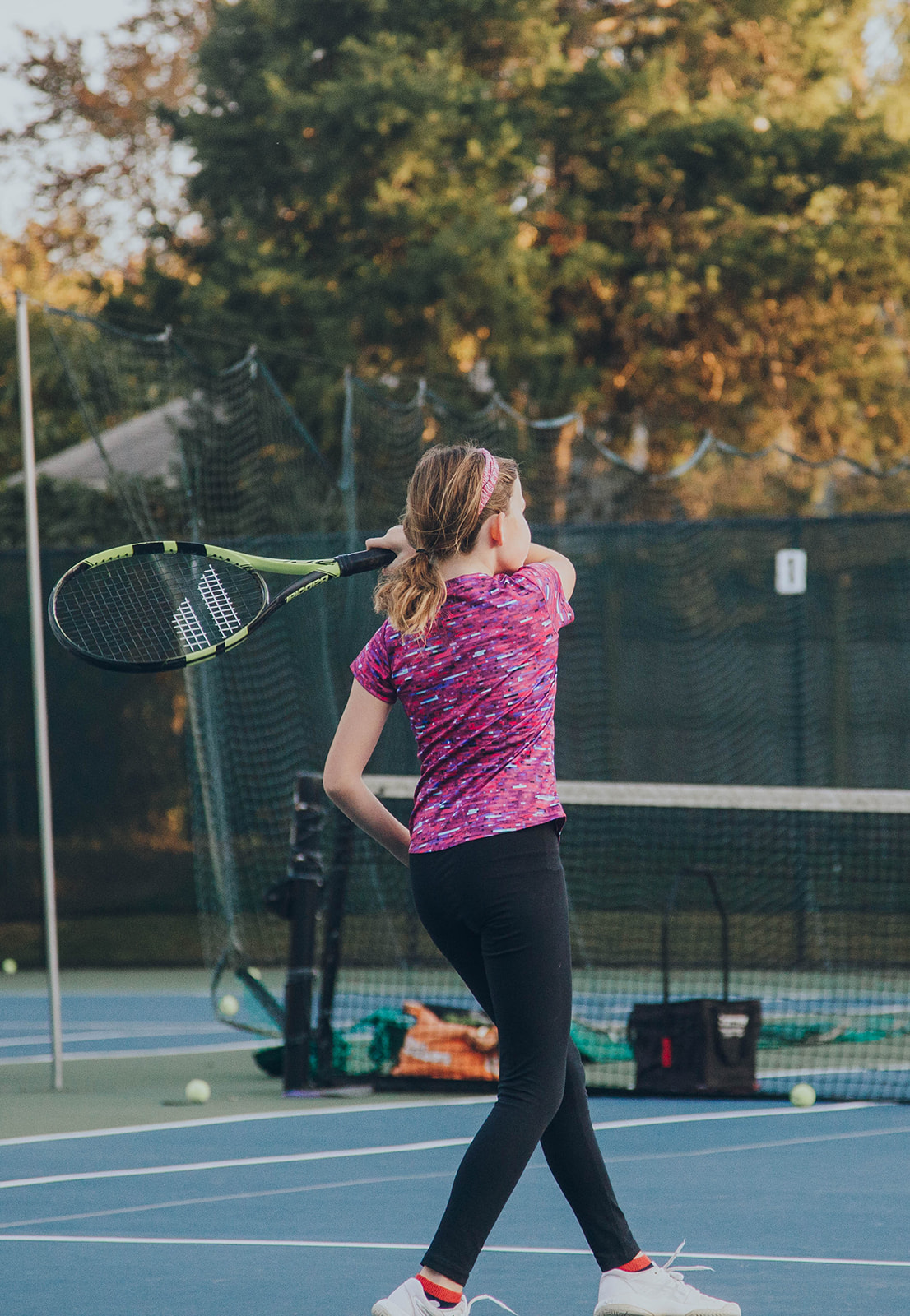 Photo of a 13 year old girl in a purple shirt learning a tennis backhand at Fox Hunt Tennis summer camp